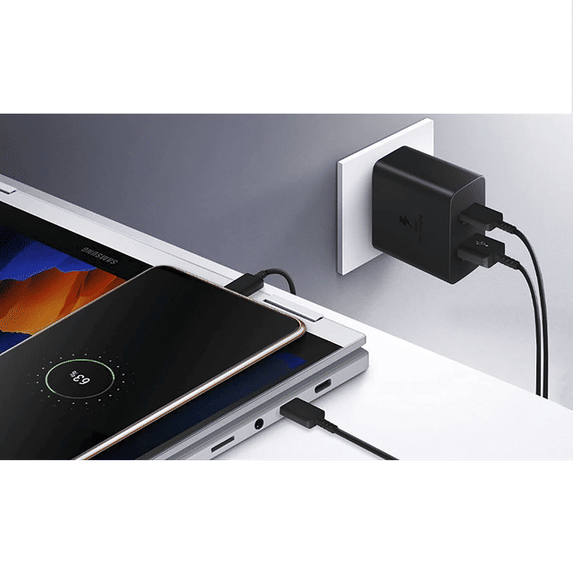 Samsung 35W USB C charger plugged into wall with black cables charging a smartphone and laptop