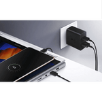 Samsung 35W USB C charger plugged into wall with black cables charging a smartphone and laptop